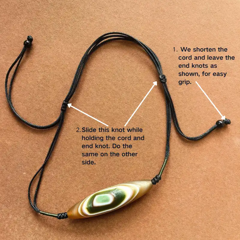 Adjustable cord knot system on Tibetan Dzi necklace, demonstrating length adjustment