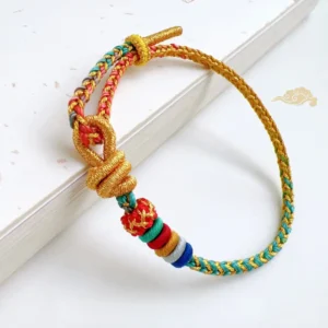 Five Elements Balance Cord Bracelet flatlay on white background with five-color woven cord