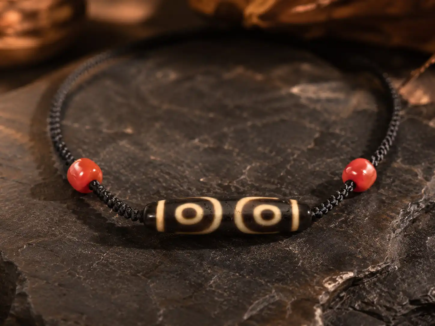 Natural stone pendant necklace with three-eye Tibetan-style Dzi bead, red agate accents, and hand-braided black cord