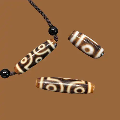 Dzi beads showing traditional eye patterns on a warm brown background