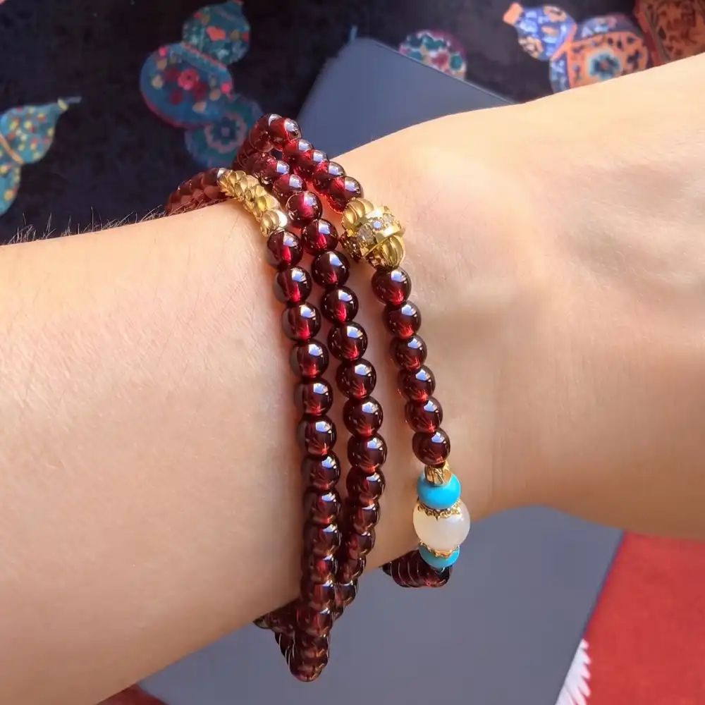 Close-up of garnet 3-wrap bracelet worn stacked on the wrist | Glint & Grain