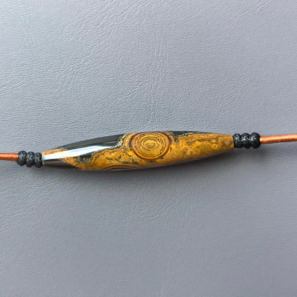 Flat-lay front view of the two-eye eye-stone lance pendant, horizontal | Glint & Grain