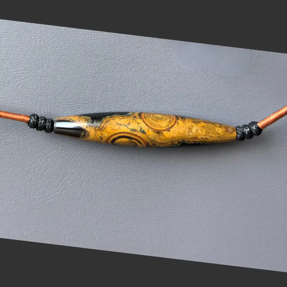 Detail of two-eye eye-stone lance pendant with hand-braided cord and sliding knot | Glint & Grain